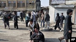 A wounded man is being helped after a suicide blast targeting a Shi'ite Muslim gathering in Kabul December 6, 2011