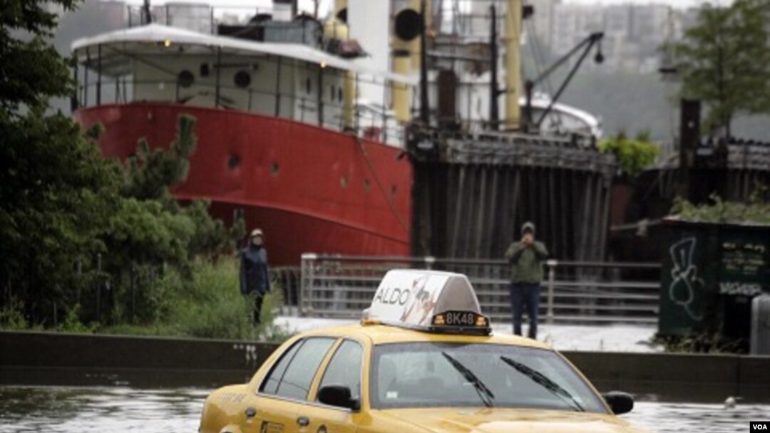 Sebuah taksi terperangkap dalam banjir di bagian barat Manhattan selagi badai Irene menerpa kota New York (Minggu, 28/7).