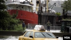 Sebuah taksi terperangkap dalam banjir di bagian barat Manhattan selagi badai Irene menerpa kota New York (Minggu, 28/7).