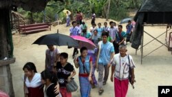 FILE - Karen refugees leave after a church service at Mae La refugee camp in Ta Song Yang district of Tak province, northern Thailand.
