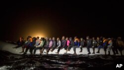 Refugees and migrants from many different African nationalities sit aboard an overcrowded rubber boat leaving Libyan territorial waters early March 5, 2017. A similar boat carrying more than 100 people sank off the coast of Libya earlier this week and dozens of people are missing.