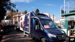 A refrigerated truck is escorted by Italian Police as it arrives at the Spallanzani hospital to deliver the first doses of vaccine for the COVID-19 in Rome, Dec. 26, 2020.