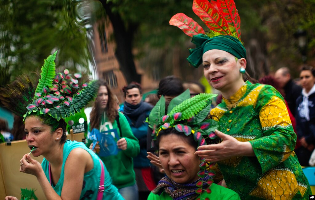 Women are seen reflected in a mirror as they get ready to take part in a performance to celebrate the Earth Day in Barcelona, Spain, April, 22, 2012. Earth Day, a day in which people across the globe hold events to celebrate the Earth's environment and sp