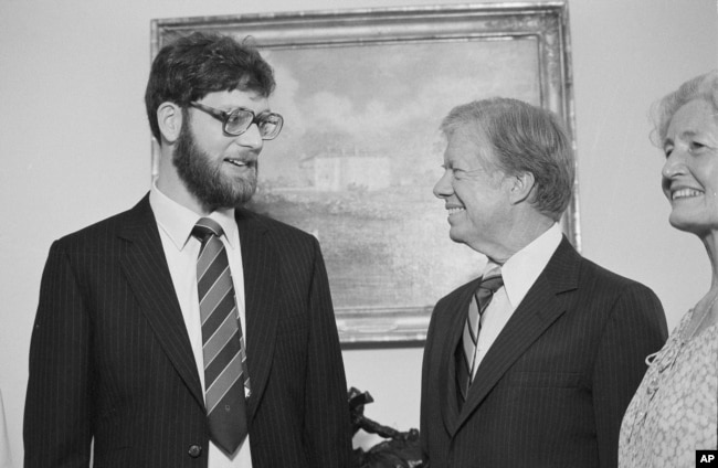 FILE - President Jimmy Carter appears with freed hostage Richard Queen at the White House, July 19, 1980. Queen was released from captivity in Iran due to health reasons.