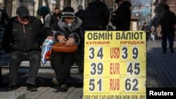 Papan bertuliskan nilai pertukaran mata uang di pusat kota Kyiv, Ukraina (25/2). (Reuters/Valentyn Ogirenko)