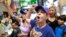 Arelys Lopez, foreground, leads a cheer as Venezuelans chant while watching televised news from their country at the El Arepazo Doral Venezuelan restaurant in Doral, Fla., April 30, 2019.