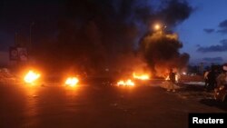 Burning obstacles are seen along a road leading to the airport in Tripoli, Libya, April 7, 2014.