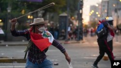 Un manifestante antigubernamental utiliza una onda durante enfrentamientos con la policía en Lima, Perú, el sábado 28 de enero de 2023, en medio de la crisis política suscitada tras la destitución en diciembre del presidente Pedro Castillo. 