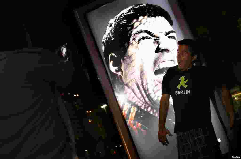 As pessoas acorrem ao muppi da publicidade da marca Adidas &quot;Tudo ou Nada&quot; com a cara de Suarez de boca aberta, pronto a morder. Copacabana, Rio de Janeiro Junho 26, 2014. 