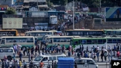 Passengers queue to get on buses in Ethiopia's capital Addis Ababa, Nov. 6, 2020, as the government carried out airstrikes in the country's restive Tigray region, prompting Sudan to close part of its border with Ethiopia.