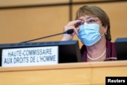 FILE - United Nations High Commissioner for Human Rights Michelle Bachelet adjusts her glasses during the opening of 45th session of the Human Rights Council, at the European U.N. headquarters in Geneva, Sept. 14, 2020.