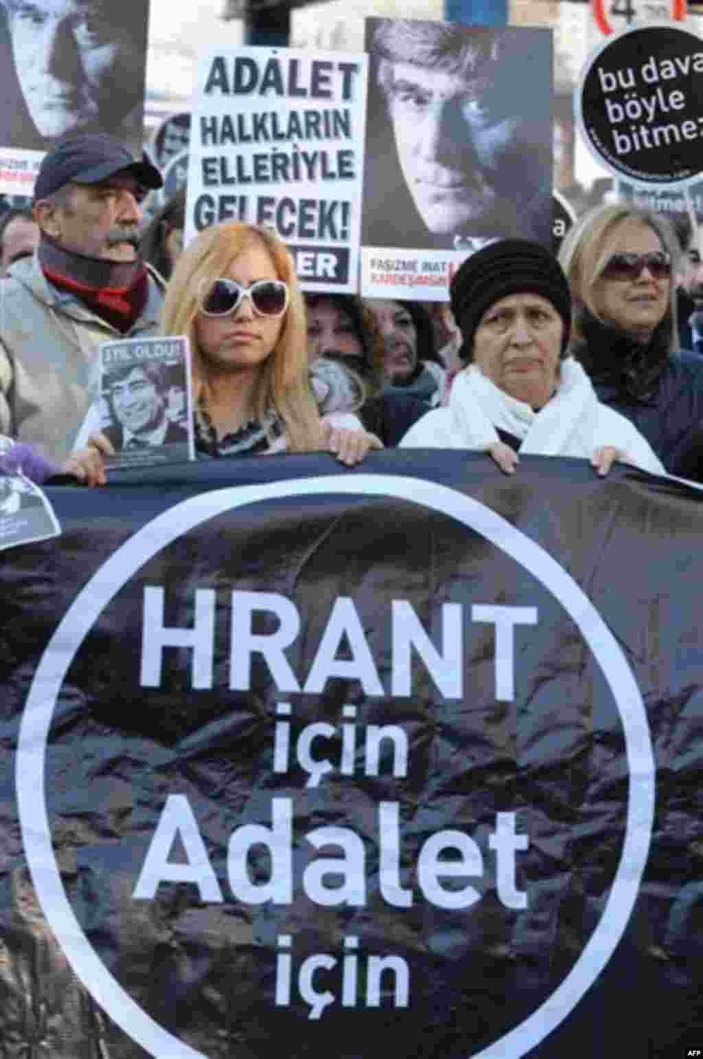 People hold placards that read ' For Hrant, for justice" outside a courthouse in Istanbul, Turkey, Tuesday, Jan. 17, 2012. A prosecutor is demanding life imprisonment for seven men accused of involvement in the killing of an ethnic Armenian journalist, H