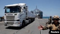 Sejumlah truk yang membawa bantuan kemanusiaan untuk Jalur Gaza bergerak melewati Dermaga Trident yang terletak di dekat pesisir Gaza, pada 25 Juni 2024. (Foto: Reuters/Amir Cohen)