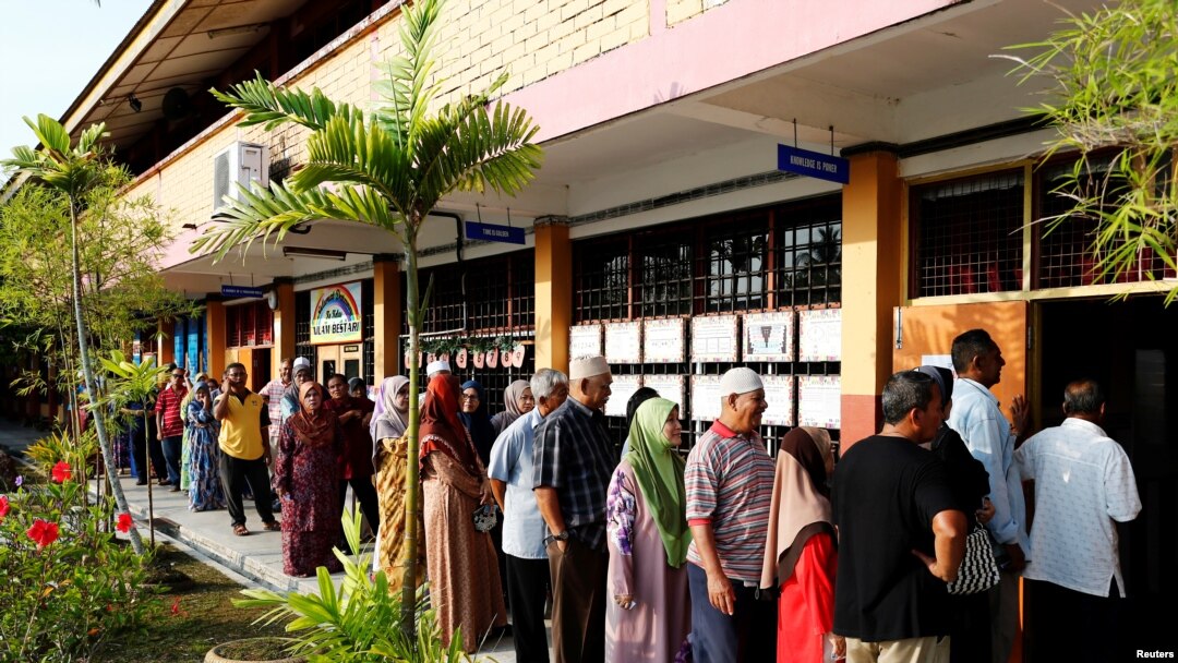 Para pemilih antre di tempat pemungutan suara untuk memasukkan suara dalam pemilu di Alor Setar, Malaysia, 9 Mei 2018. Hingga pukul 1 siang waktu setempat, 55 persen pemilih sudah memasukkan suara. 
