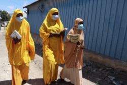 In this file photo taken on March 19, 2020, students walk in a Mogadishu neighborhood wearing face masks as protective measure against the COVID-10 coronavirus.