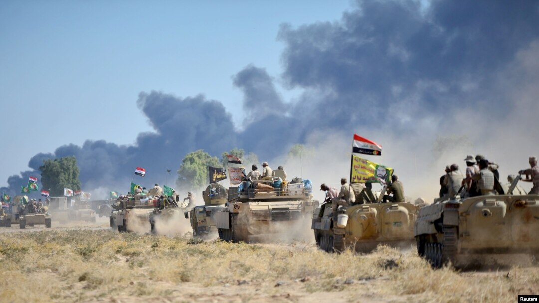 Pasukan Mobilisasi Khusus Syiah (PMF) dan tentara Irak mengendarai kendaraan lapis baja di pinggiran Hawija, Irak, 4 Oktober 2017.
