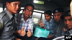 Detained Myanmar journalists Wa Lone, (L) and Kyaw Soe Oo (3rd-R) are escorted by police from the courthouse as they are taken to prison after the first day of trial in Yangon, July 16, 2018.