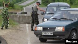 Separatistas prorrusos revisan vehículos en un puesto de control cerca de la ciudad de Lugansk, en el este de Ucrania.