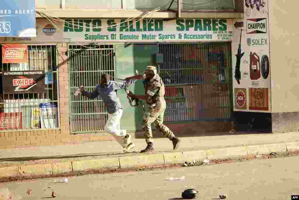 A Zimbabwean soldier strikes a man along a street in Harare after protests erupted over alleged fraud in the country&#39;s election.