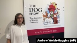 Anne Drozd, museum coordinator at Ohio State University's Billy Ireland Cartoon Library Museum, stands at the entrance to the library's new exhibit, "The Dog Show," on Thursday, June 24, 2021, in Columbus, Ohio(AP Photo/Andrew Welsh-Huggins)