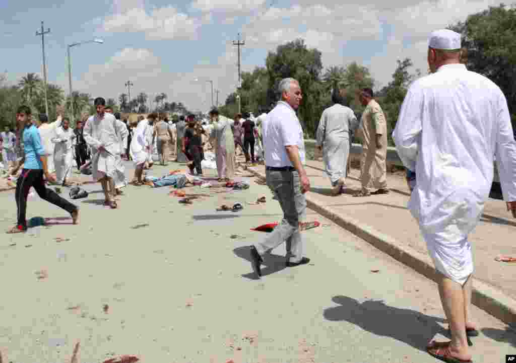 People gather at the scene of a bomb attack in Baquba, northeast of Baghdad, Iraq, May 17, 2013. 