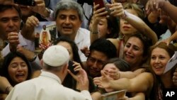 Pope Francis is cheered by faithful as he arrives in the Paul VI hall at the Vatican, Aug. 5, 2015. 