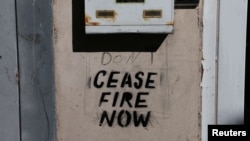 FILE - Graffiti on a wall reads "cease fire now" with the word "don't" added over it, in Tel Aviv, Israel, Oct. 24, 2024.