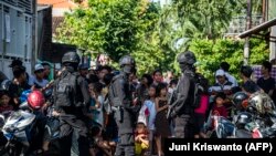 Anggota polisi anti-terorisme Densus 88 mengepung sebuah jalan ketika mereka menggeledah sebuah rumah di Surabaya, Jawa Timur, pada 19 Juni 2017, menyusul penangkapan seorang pria yang diduga terkait dengan kelompok ISIS. (Foto: AFP)