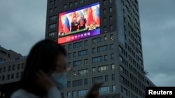 北京一座大楼的巨大屏幕显示中国领导人习近平与俄罗斯总统普京在人民大会堂签署协议的镜头。(2026年5月20日)