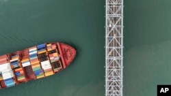 Un buque de carga navega bajo el puente de Las Américas a través del Canal de Panamá, en la Ciudad de Panamá, el jueves 13 de junio de 2024.