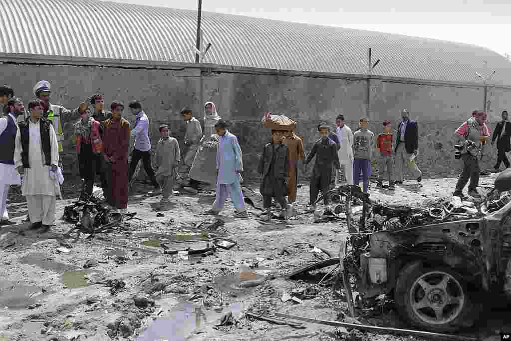 Pejalan kaki berjalan melewati lokasi ledakan militan di Kabul (AP).