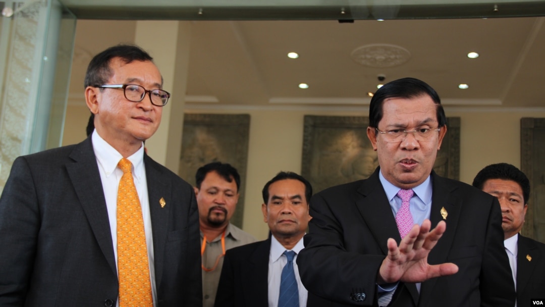 PM Kamboja Hun Sen (kanan) bersama Sam Rainsy, pemimpin partai CNRP (kiri), seusai pemilihan anggota Komisi Pemilu Baru di Phnom Penh, Kambojia, 9 April 2015.