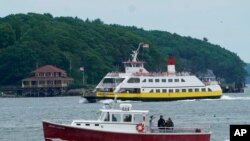 A private charter boat, foreground, and an automobile ferry motor toward Portland harbor, in Portland, Maine, July 8, 2021. Tropical Storm Elsa is expected to dump up to 4 inches of rain when it passes through the Gulf of Maine on Friday. 