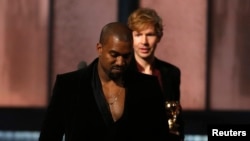 Beck melihat Kanye West yang berpura-pura mengambil alih panggung setelah Beck meraih penghargaan album tahun ini untuk "Morning Phase," pada Grammy Awards ke-57 di Los Angeles, California (8/2). (Reuters/Lucy Nicholson)