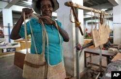 FILE - A woman displays traditional handmade bags called noken for sale at a market in Jayapura, Papua province, Indonesia, Oct. 1, 2024.