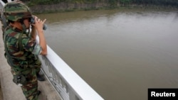 FILE - A South Korean army soldier standing on a bridge searches for missing people swept away by sudden rising water in the Imjin River near the demilitarized zone separating the two Koreas.