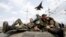 A fighter jet flies above as Ukrainian soldiers sit on an armoured personnel carrier in Kramatorsk, in eastern Ukraine, April 16, 2014. 
