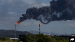 FILE - Flare stacks release gases at the Jose Antonio Anzoategui oil complex in Barcelona, Venezuela, Jan. 9, 2024. 