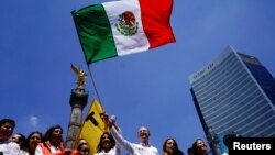 Ricardo Anaya, presidential candidate for the National Action Party (PAN), waves a Mexican flag during his closing campaign rally in Mexico City, Mexico, June 24, 2018.