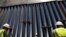 FILE - Construction workers check a new section of bollard wall in Santa Teresa, N.M., as seen from the Mexican side of the border, April 23, 2018, on the outskirts of Ciudad Juarez, Mexico.