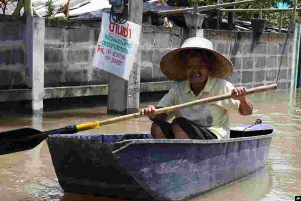 A woman paddles through an Ayutthaya neighborhood, Oct. 6, 2011. (VOA - D.Schearf)