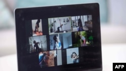 FILE - YogaUP founder Chaukei Ngai (top center) leads a group of students via the Zoom online video conferencing platform during a livestreamed yoga class in Hong Kong on March 30, 2020..