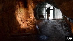 FILE - Cave specialist Christian Casseyas gives a tour of the Goyet cave, where 96 bones and three teeth from five Neanderthal individuals were found, in Goyet, Belgium, on Dec. 19, 2016.