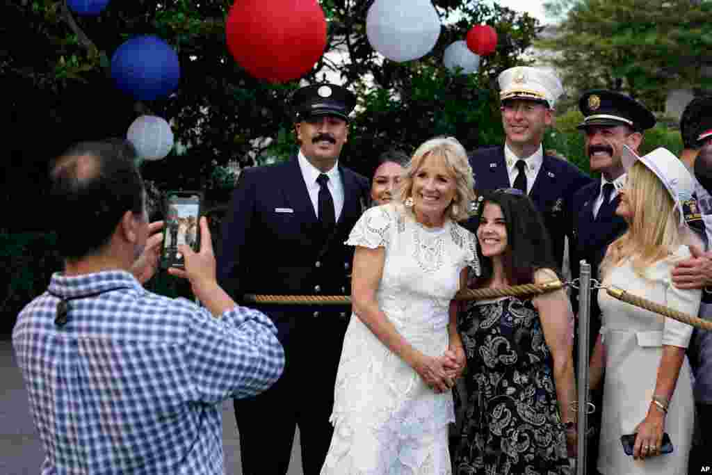 First lady Jill Biden poses for photos with attendees during an Independence Day celebration on the South Lawn of the White House, July 4, 2021, in Washington. 