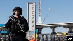 FILE - During a drill, Customs and Border Protection officials block the entrance to the San Ysidro Port of Entry, Jan. 10, 2019, as seen from Tijuana, Mexico. 
