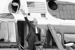 FILE - President Richard Nixon waves goodbye from the steps of his helicopter outside the White House after he gave a farewell address to members of the White House staff, Aug. 9, 1974.