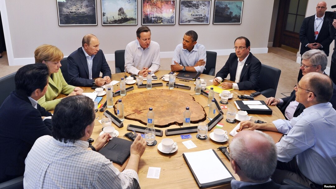 Para pemimpin negara-negara G8 dalam KTT di Irlandia Utara. Dari kiri searah jarum jam: Kanselir Jerman Angela Merkel (berbaju hijau), Presiden Rusia Vladimir Putin, PM Inggris David Cameron, Presiden AS Barack Obama, Presiden Perancis Hollande, dan para pemimpin G8 di Lough Erne, dekat Enniskillen, Irlandia Utara (18/6).