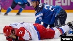 Atlet Hoki Es Rusia Alexei Yemelin menutupi wajahnya setelah terkena pukulan atlet FInlandia Lauri Korpikoski (kanan) dalam putaran kedua pertandingan perempat final hoki es pria di Olimpiade Musim Dingin 2014 di Sochi, Rusia (19/2).