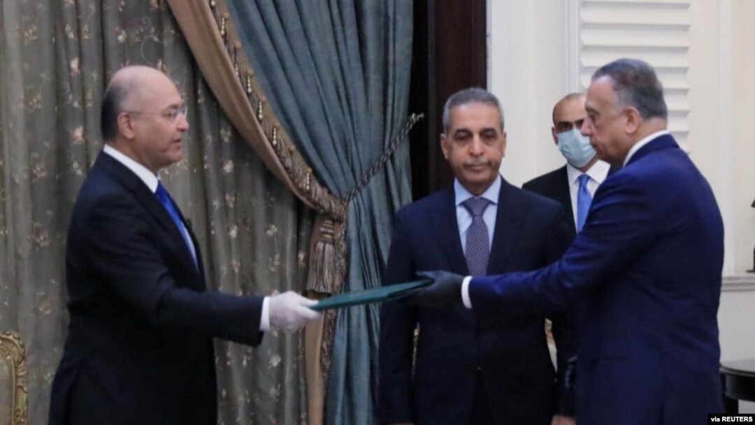 Presiden Irak Barham Salih (kiri) menyerahkan dokumen kepada Perdana Menteri baru, Mustafa al-Kadhimi di Baghdad, Irak, 9 April 2020. (Foto: dok).