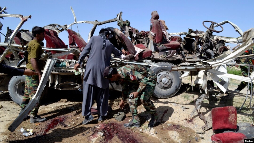 Petugas keamanan mengumpulkan bukti-bukti di dekat kendaraan yang hancur akibat ledakan bom di Quetta (23/5). Sedikitnya 11 personel keamanan dan dua warga sipil tewas dalam insiden tersebut.